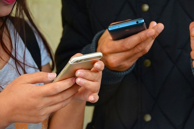 Pessoas jovens com um celular às mãos